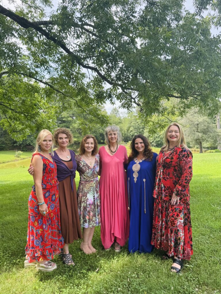 6 women 6 expressions exhibition artists - shown outdoors, pictured as a group of women artists in colorful clothing