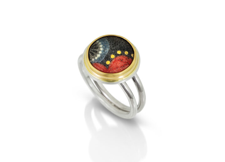 Round enamel in black blue and red with gold dots and gold bezel. Split silver band