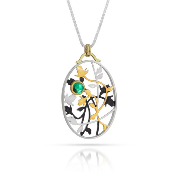 Oval pendant with silver, black, and gold roses and vines with emerald
