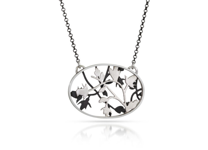 Black and silver oval necklace with layered rose and vine shapes