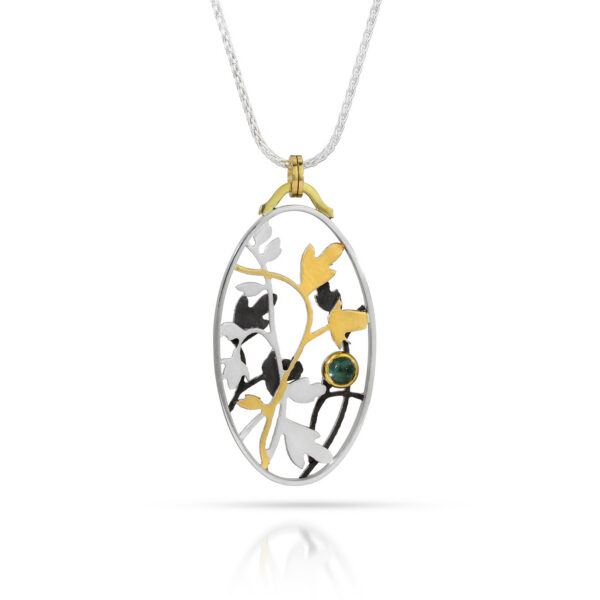 Oval pendant with silver, black, and gold roses and vines with blue tourmaline