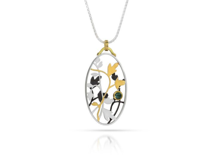 Oval pendant with silver, black, and gold roses and vines with blue tourmaline