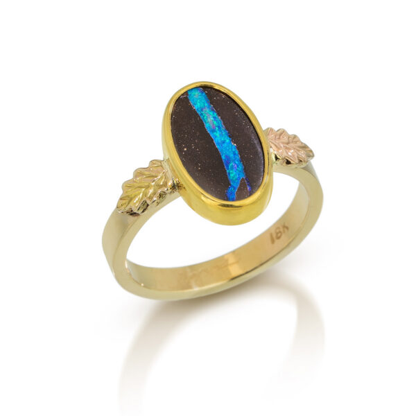 Blue and brown boulder opal oval set in solid gold ring with accent oak leaves