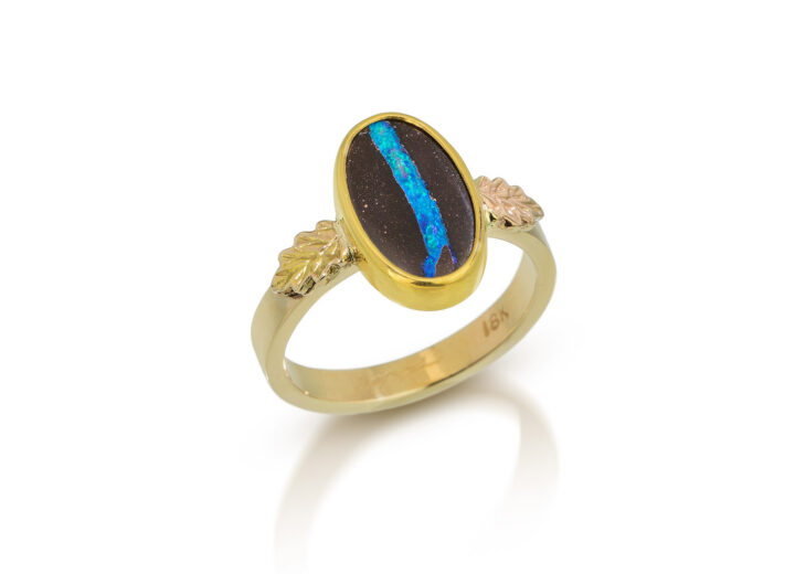 Blue and brown boulder opal oval set in solid gold ring with accent oak leaves